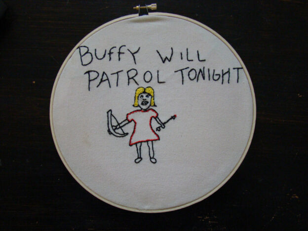 Embroidery showing stick-figure Buffy with crossbow and arrow that reads "Buffy will patrol tonight"